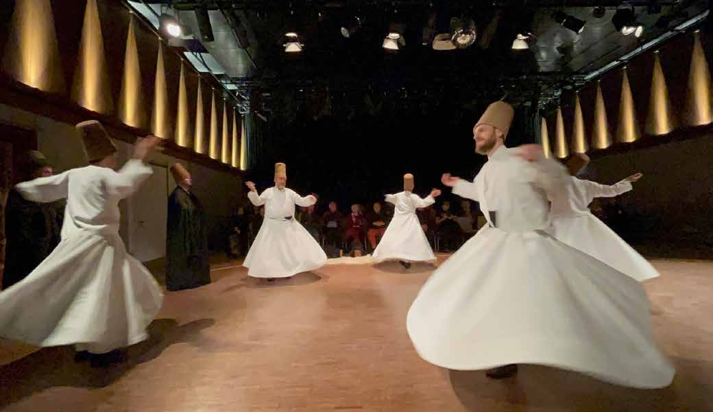 Dervisci danzanti dell'Ordine Mevlevi nei loro abiti bianchi durante un'esibizione pubblica a Norimberga il 17 dicembre 2022. Foto: © Mevlevi Orden Nürnberg.